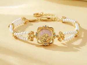Primer plano de una pulsera de perlas de doble vuelta con charm de ángel chapado en oro.