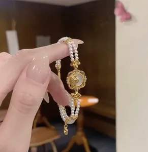 Primer plano detallado de una pulsera de perlas vintage con colgante de ángel