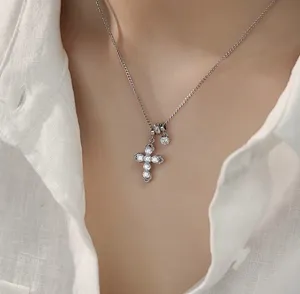 Primer plano de un elegante collar con colgante de cruz plateada y cristales brillantes