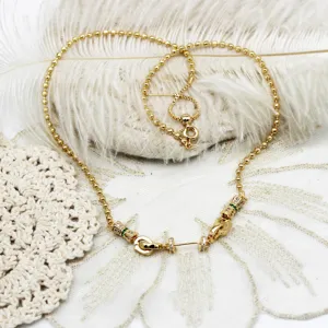 Primer plano de una cadena de collar DIY bañada en oro 18K con dijes de abanico pavé