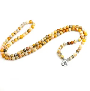 Vue de detail du collier de perles de priere en agate avec pendentif lotus en metal.