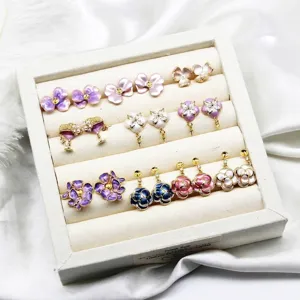 Collection of floral enamel earring components in a beige jewelry display tray.