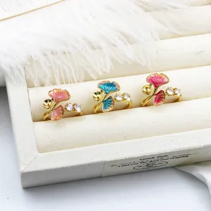 Detail view of colorful enamel ginkgo leaf rings with gold plating and clear gems