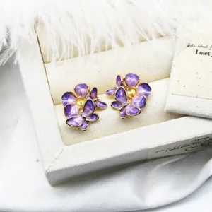 Macro detail of purple enamel flower and butterfly earring settings for DIY jewelry making