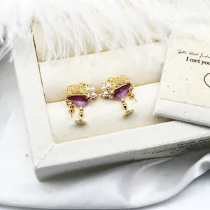 Detail view of cocktail glass earrings with purple enamel, white pearls and crystals