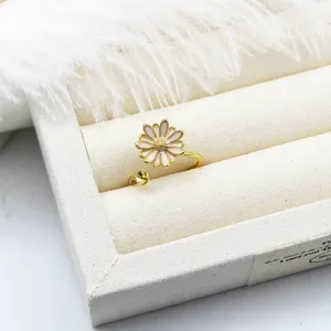 Macro detail of a white enamel daisy adjustable ring base with a gold finish