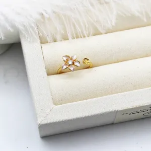 Detail of gold-plated adjustable ring featuring an enamel 3D flower with crystal center