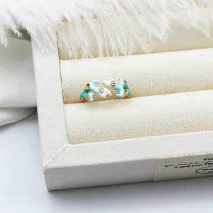 Close-up of elegant light blue and white enameled coral ring with inset zircons