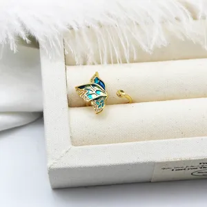 Detailed view of an enamel butterfly adjustable ring with gold plating and zircons