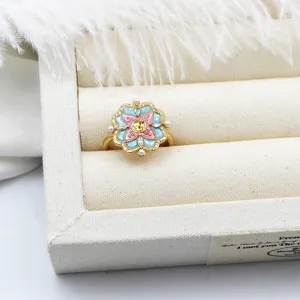 Close-up of colorful enamel flower ring with pearl accents and gold-plated adjustable band