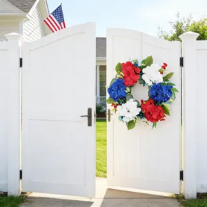 Ghirlanda patriottica di ortensie rosse bianche e blu su un cancello bianco da giardino