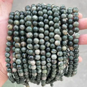 Close-up detail of natural green wood grain stone round beads for DIY jewelry making