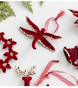 Detail of burgundy flocked dragonfly and reindeer Christmas ornaments with gold glitter