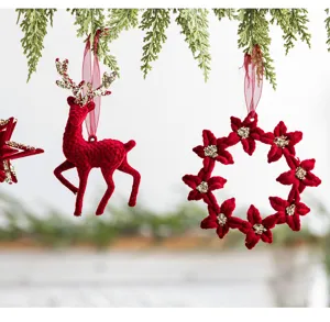 Close-up detail of premium red flocked reindeer and floral wreath Christmas ornaments