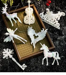 Macro view of pearlescent white Christmas ornaments including angel wings and unicorn