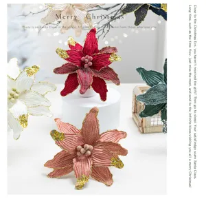 Detailed view of burgundy and champagne velvet Christmas flowers with glitter edges.