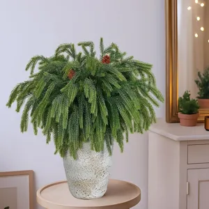 Detailansicht üppiger künstlicher Norfolk-Kiefernzweige in einer weißen rustikalen Vase.