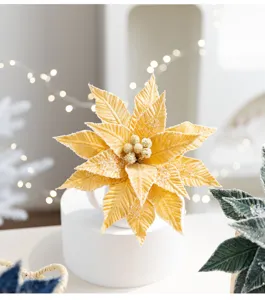 Detailed view of a golden velvet artificial poinsettia flower with elegant crystal accents.