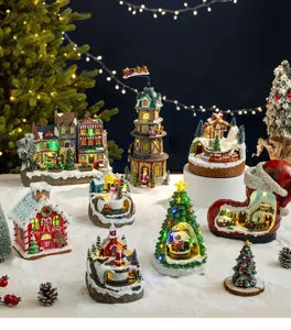 Detailed view of assorted glowing Christmas village houses and rotating musical boxes