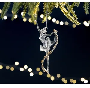 Macro view of clear ballet dancer ornament with gold sequins on Christmas tree.
