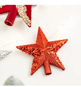 Close-up van een levendige rode glitter kerstboomtop ster met fonkelende lovertjes.