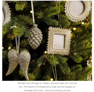 Nahaufnahme von Champagner-Harz Weihnachtsbaum-Hängeornamenten, Zapfen und Fotorahmen.