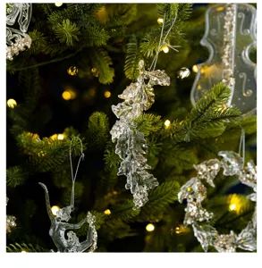 Detailed view of clear acrylic leaf ornament with sequins on a lighted Christmas tree