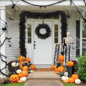 Detailed view of black Norfolk pine garland and wreath set on a Halloween porch