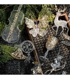 Close-up macro view of sparkling acrylic Christmas ornaments with gold sequins on tray