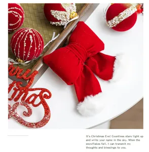 Close-up detail of wine red velvet Christmas bow and ball ornaments with glitter accents