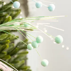 Pastel colored Christmas decoration branch with soft pom-poms for DIY holiday tree decor