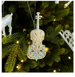 Macro view of white iridescent cello shaped Christmas ornament on a lighted green tree