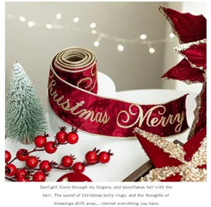 Close-up of burgundy velvet Christmas ribbon with gold Merry Christmas lettering