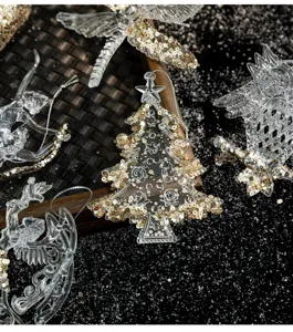 Close-up of clear acrylic Christmas ornaments with gold sequins on dark background