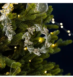 Close-up of clear acrylic wreath ornament with gold sequins on Christmas tree