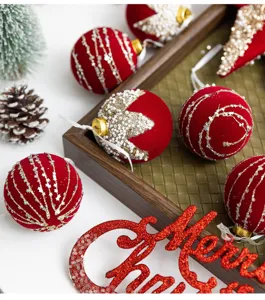 Detailed view of burgundy flocked Christmas balls with glitter patterns and Merry Christmas sign