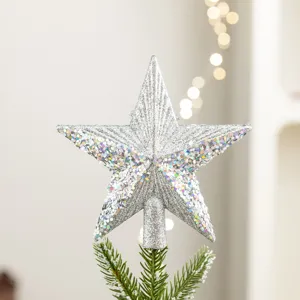Glinsterende zilveren kerstboomtop ster met iriserende lovertjes op een dennentakje