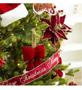 Close-up detail of elegant wine red velvet bow and Merry Christmas ribbon on tree