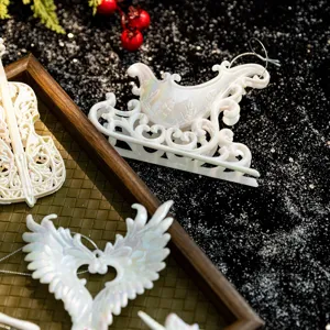 Set of white iridescent Christmas ornaments with angel wings and sleigh for tree decoration