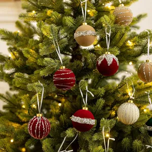 Elegant flocked Christmas tree ornaments with pearls and glitter on festive pine branches