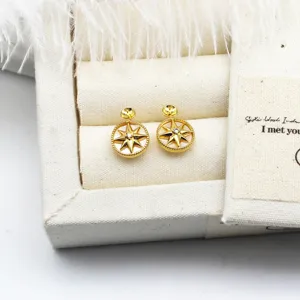 Dettaglio orecchini a stella bussola placcati oro 18K con conchiglia bianca e zircone