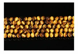 Vue macro de perles d'oeil de tigre jaune naturel avec une texture chatoyante dorée unique