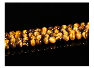 Détail macro de perles rondes naturelles en œil de tigre jaune 7A pour bijoux.