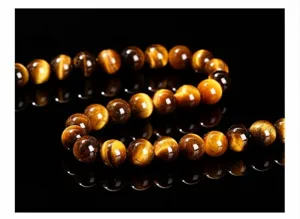 Gros plan montrant les textures de perles d'oeil de tigre jaune naturel sur fond noir