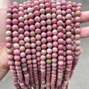 Close-up detail of natural pink rhodonite round stone beads with wood grain texture