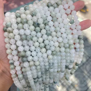 Close-up detail of natural Tianshan ice green jade round beads showing translucent texture