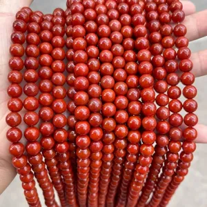 Close-up view showing the glossy texture of persimmon red South Red Agate round beads