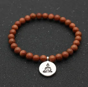 Detailed view of brown goldstone bead bracelet with silver Buddha pendant, close-up.