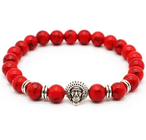 Close-up detail of the red beaded bracelet featuring a unique silver chief charm and polished stones.
