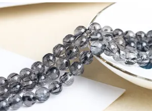 Détail macro de perles rondes en quartz rutilé noir naturel pour la création de bijoux DIY